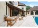 Elegant outdoor patio with travertine flooring, wood columns, and a view of the pool at 1118 Seminole Dr, Fort Mill, SC 29707