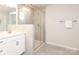 Bathroom featuring an enclosed walk in shower with tiled walls, glass door, and updated fixtures at 1119 Bellshill Dv, Indian Trail, NC 28079