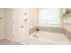 Bathroom featuring tiled tub, modern faucet fixtures, and natural light at 1119 Bellshill Dv, Indian Trail, NC 28079