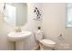 Powder room features a pedestal sink, modern mirror, and a white toilet at 1119 Bellshill Dv, Indian Trail, NC 28079