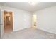 This carpeted bedroom is neutral with cream walls, two doorways and a white panel door at 1119 Bellshill Dv, Indian Trail, NC 28079