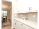 Elegant counter space with white cabinets and a decorative cake stand, flowing into a sunlit dining area at 1119 Bellshill Dv, Indian Trail, NC 28079