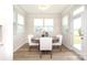 Bright dining room with a round wood table, comfortable upholstered chairs, and many windows at 1119 Bellshill Dv, Indian Trail, NC 28079