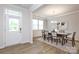 Well-lit dining room featuring a modern table set, complemented by an airy entrance for natural light and flow at 1119 Bellshill Dv, Indian Trail, NC 28079