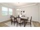 Bright dining room with a modern chandelier, a dark wood table and neutral-toned decor that enhances the space at 1119 Bellshill Dv, Indian Trail, NC 28079