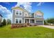 Two-story home with gray siding, stone accents, covered porch, and attached two-car garage at 1119 Bellshill Dv, Indian Trail, NC 28079