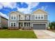 Two-story home with gray siding, stone accents, covered porch, and attached two-car garage at 1119 Bellshill Dv, Indian Trail, NC 28079
