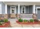 Inviting covered front porch with stone pillars and a cozy seating area at 1119 Bellshill Dv, Indian Trail, NC 28079