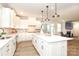 Open kitchen with white cabinets, a center island with seating, seamlessly connects to a cozy living space at 1119 Bellshill Dv, Indian Trail, NC 28079