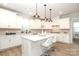 Bright kitchen with white cabinetry, a central island with bar stools, and modern pendant lighting at 1119 Bellshill Dv, Indian Trail, NC 28079