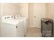Neat laundry room with tile floor, side-by-side washer and dryer, and wire shelving at 1119 Bellshill Dv, Indian Trail, NC 28079