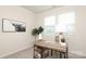 Bright office space featuring a rustic wood desk, two windows, and artwork at 1119 Bellshill Dv, Indian Trail, NC 28079