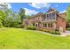 A spacious brick house with a screened in porch overlooking a lush green lawn and mature trees at 1200 Firethorne Club Dr, Marvin, NC 28173
