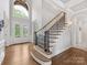 Bright foyer with hardwood floors, a staircase with iron railings, and a large arched window at 1200 Firethorne Club Dr, Marvin, NC 28173
