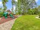 Lush backyard with a playground, fire pit, and mature trees, creating an ideal space for outdoor enjoyment at 1200 Firethorne Club Dr, Waxhaw, NC 28173