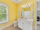 Bright yellow bathroom featuring a single vanity, toilet, and window for a cheerful and functional space at 1200 Firethorne Club Dr, Waxhaw, NC 28173