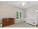 Bedroom room with neutral paint, window views, crib, dresser, and neutral decor at 1200 Firethorne Club Dr, Waxhaw, NC 28173