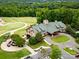 Aerial view of a clubhouse with golf carts and verdant landscaping at 1200 Firethorne Club Dr, Waxhaw, NC 28173