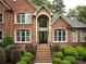 Elegant brick home facade highlighting arched entrance and meticulous landscaping at 1200 Firethorne Club Dr, Waxhaw, NC 28173
