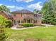 Beautiful brick home with large windows, screened porch, and lush landscaping at 1200 Firethorne Club Dr, Waxhaw, NC 28173