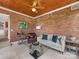 Comfortable living room featuring a red brick wall, wood ceiling, and neutral-colored furnishings at 1200 Firethorne Club Dr, Waxhaw, NC 28173