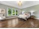 Large main bedroom with hardwood floors, tray ceiling, fan and large window at 1200 Firethorne Club Dr, Waxhaw, NC 28173