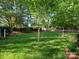Spacious backyard with lush green grass, landscaping, and partial fencing at 12632 Landing Green Dr, Charlotte, NC 28277