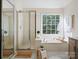 Well-lit bathroom with a soaking tub, separate shower, and stylish vanity at 12632 Landing Green Dr, Charlotte, NC 28277