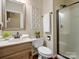 Tastefully designed bathroom with a glass-enclosed shower, wood vanity, and neutral decor at 12632 Landing Green Dr, Charlotte, NC 28277