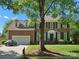 Charming brick home boasts a well-manicured lawn, classic shutters, and a welcoming two-car garage at 12632 Landing Green Dr, Charlotte, NC 28277
