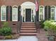 Elegant brick home entry featuring arched windows, black shutters, and a classic door with detailed trim at 12632 Landing Green Dr, Charlotte, NC 28277