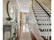 Inviting hallway featuring hardwood floors, staircase, and a view of the dining area and kitchen at 12632 Landing Green Dr, Charlotte, NC 28277