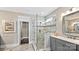Bathroom with a glass shower, rain shower head, built-in seat, gray vanity and mirror, and closet access at 13241 Cozy Ct, Charlotte, NC 28215
