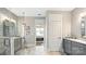 Modern bathroom with marble floors, glass shower doors, and double vanity with square mirrors and gray cabinetry at 13241 Cozy Ct, Charlotte, NC 28215