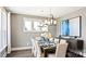 Well lit dining room featuring an elegant chandelier, large windows, and a modern table set for a dinner party at 13241 Cozy Ct, Charlotte, NC 28215