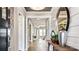 Hallway with hardwood floors, white trim, entry table with decorative vases, and access to other rooms at 13241 Cozy Ct, Charlotte, NC 28215