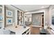 A home office featuring a white quartz desk, grey walls, built-in shelving, and a view into the kitchen at 13241 Cozy Ct, Charlotte, NC 28215