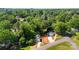 An overhead view of a home and detached garage surrounded by mature trees and a concrete driveway at 1411 Duhart Ave, Gastonia, NC 28054