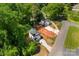 An overhead view of the house and detached garage with concrete driveways and lush, mature trees at 1411 Duhart Ave, Gastonia, NC 28054