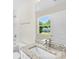 This bathroom has a granite countertop with white cabinets and a view of the neighborhood at 1411 Duhart Ave, Gastonia, NC 28054