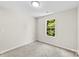 This is a carpeted bedroom with a window for natural lighting and neutral walls at 1411 Duhart Ave, Gastonia, NC 28054