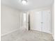 This bedroom features neutral paint and carpet with a double-door closet and an open doorway at 1411 Duhart Ave, Gastonia, NC 28054