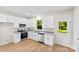 Bright kitchen features white cabinets, stainless steel appliances, granite countertops, and wood-look flooring at 1411 Duhart Ave, Gastonia, NC 28054
