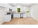 Modern kitchen with stainless steel appliances, granite countertops, white cabinets, a window above the sink, and hardwood floors at 1411 Duhart Ave, Gastonia, NC 28054