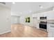 Bright, open-concept kitchen boasting stainless appliances, granite counters, white cabinets, hardwood floors, and a view to the living room at 1411 Duhart Ave, Gastonia, NC 28054
