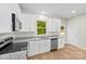 Bright kitchen features white cabinets, stainless steel appliances, granite countertops, and wood-look flooring at 1411 Duhart Ave, Gastonia, NC 28054