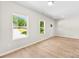 Inviting living room featuring hardwood floors, neutral paint, and large windows providing ample natural light and view of the driveway at 1411 Duhart Ave, Gastonia, NC 28054