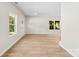 Bright living room with hardwood floors, a neutral color scheme, with ample natural light streaming through two windows and an exterior door at 1411 Duhart Ave, Gastonia, NC 28054