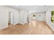 Open-concept living room with hardwood floors, neutral paint, and access to staircase, exterior door, and window overlooking green space at 1411 Duhart Ave, Gastonia, NC 28054