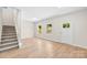 Open-concept living room featuring wood-look floors, white walls, stairs and a white front door at 1411 Duhart Ave, Gastonia, NC 28054
